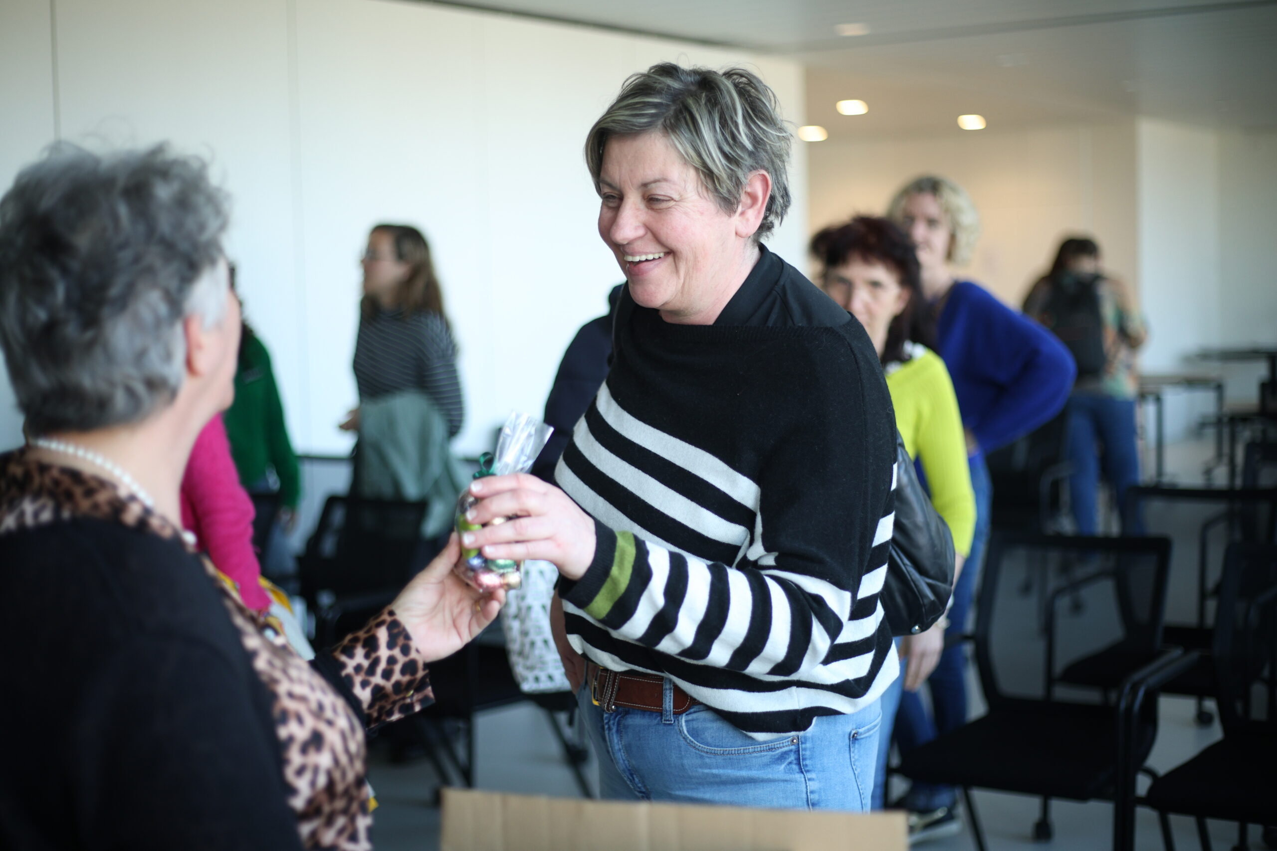 Verzorgende Christa ontvangt een cadeautje van Mieke Ruys, algemeen directeur Familiezorg.